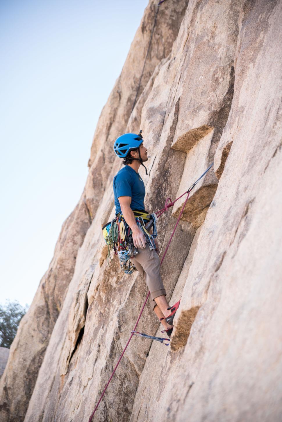 Free Image of Rock climber mid-ascent on steep natural rock face 