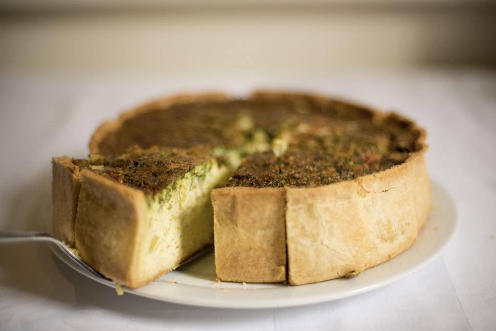 Free Image of Freshly baked quiche served on a white ceramic plate 