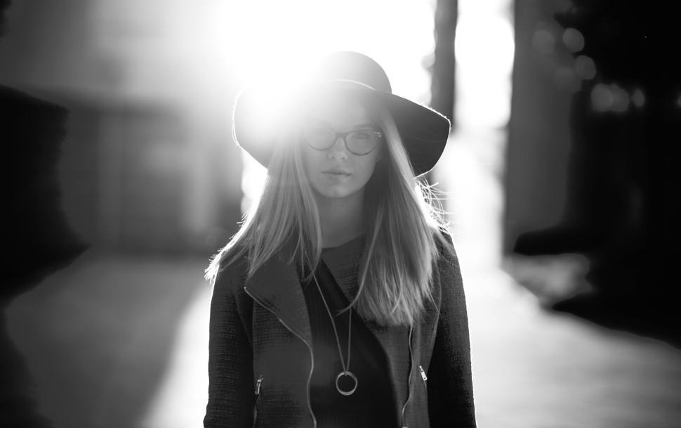 Free Image of Person wearing a hat walking in bright sunlight. 