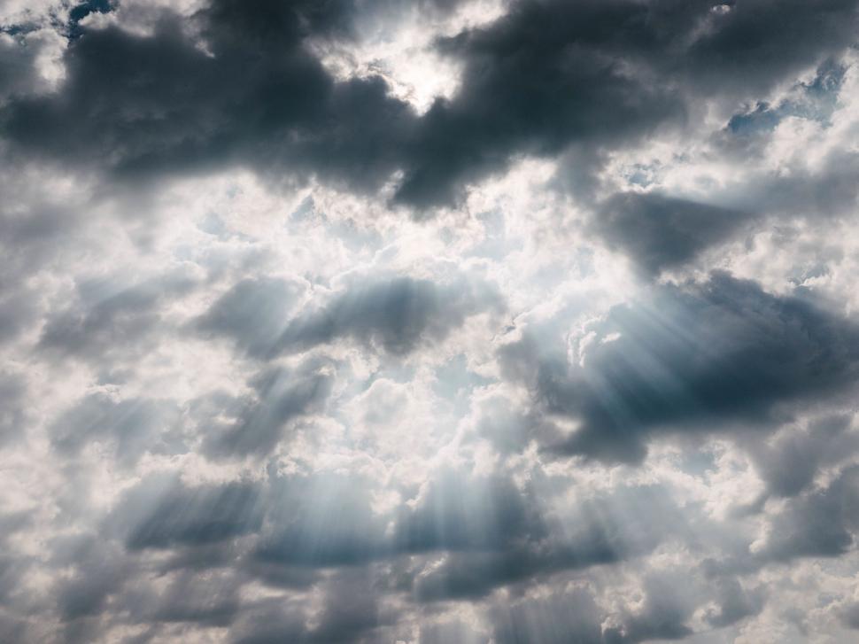 Free Image of Sunlight filtering through the clouds creating radiant beams. 