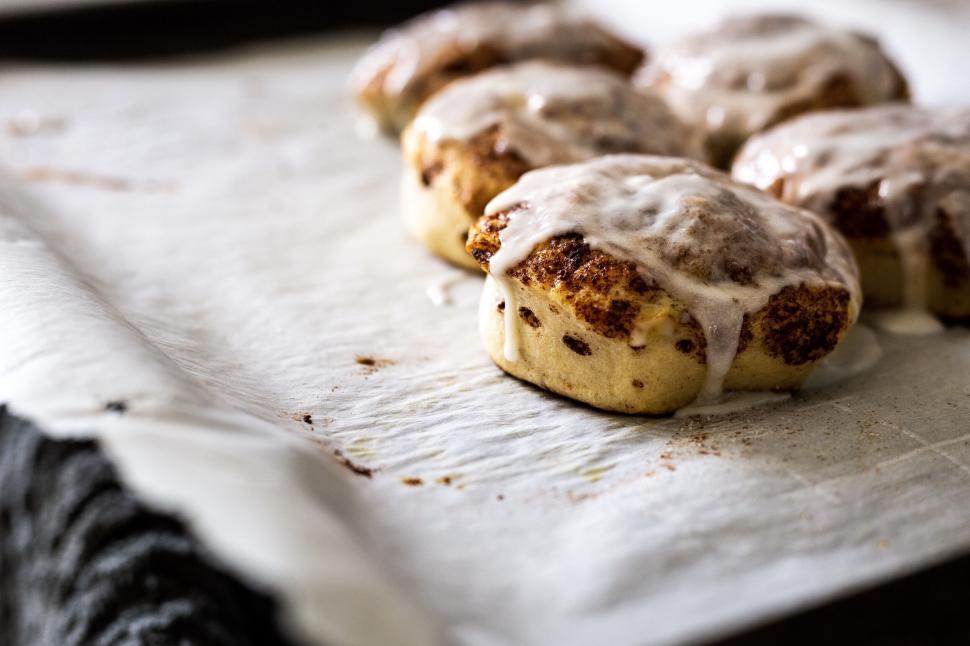 Free Image of Freshly baked cinnamon rolls covered with glaze 