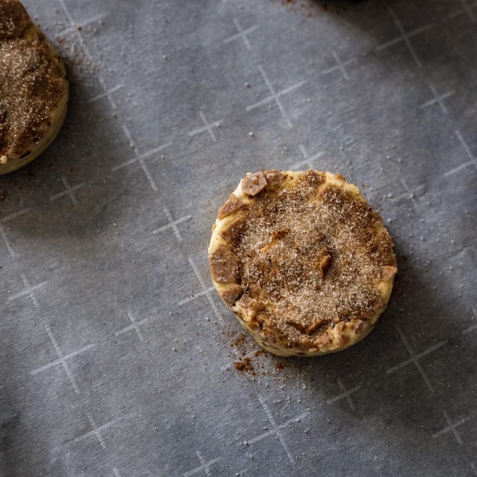 Free Image of Cinnamon roll dough being prepared on baking sheet 