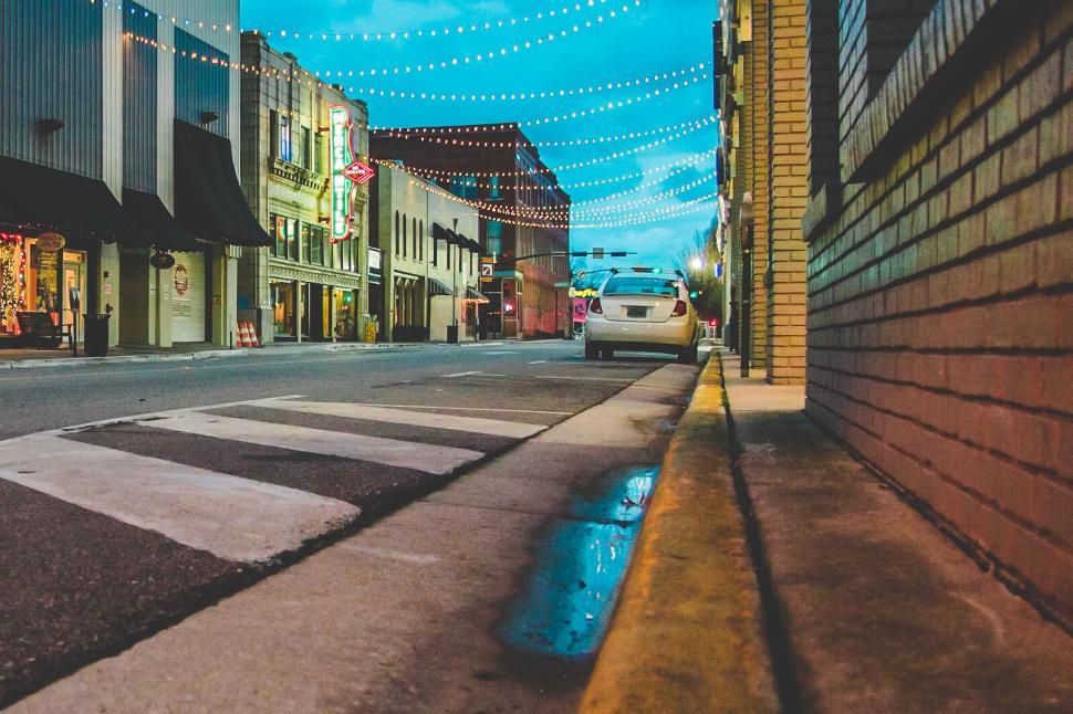 Free Image of Urban street view at twilight with lights overhead. 