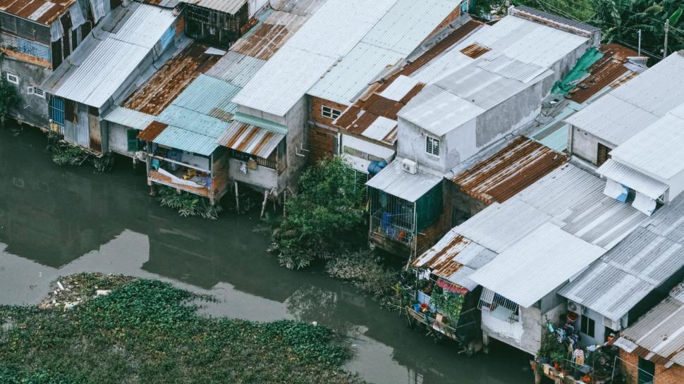Free Image of Houses along a canal some on stilts, showing reflections. 