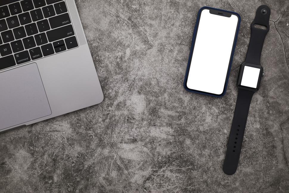 Free Image of Laptop with smartphone and smartwatch on a concrete surface. 