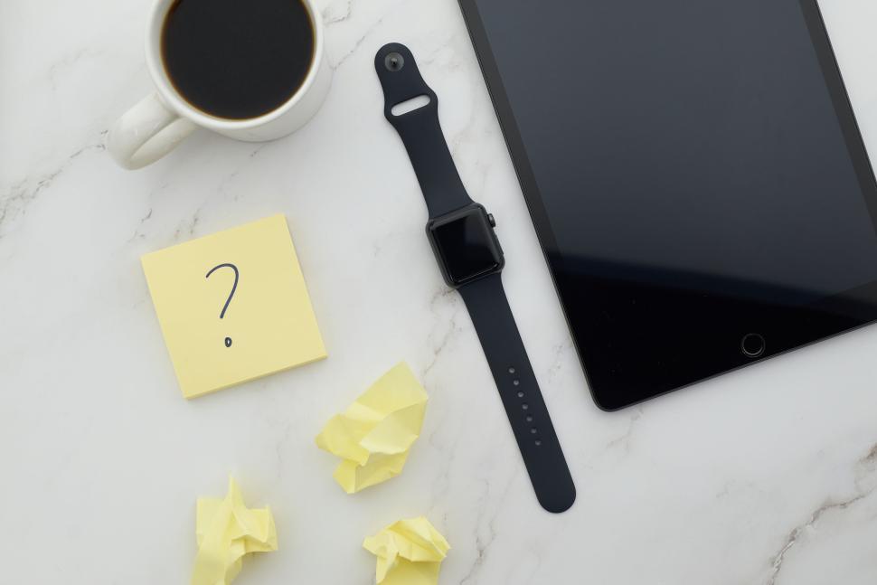 Free Image of Contemporary desk setup with tablet, watch, coffee, and notes. 