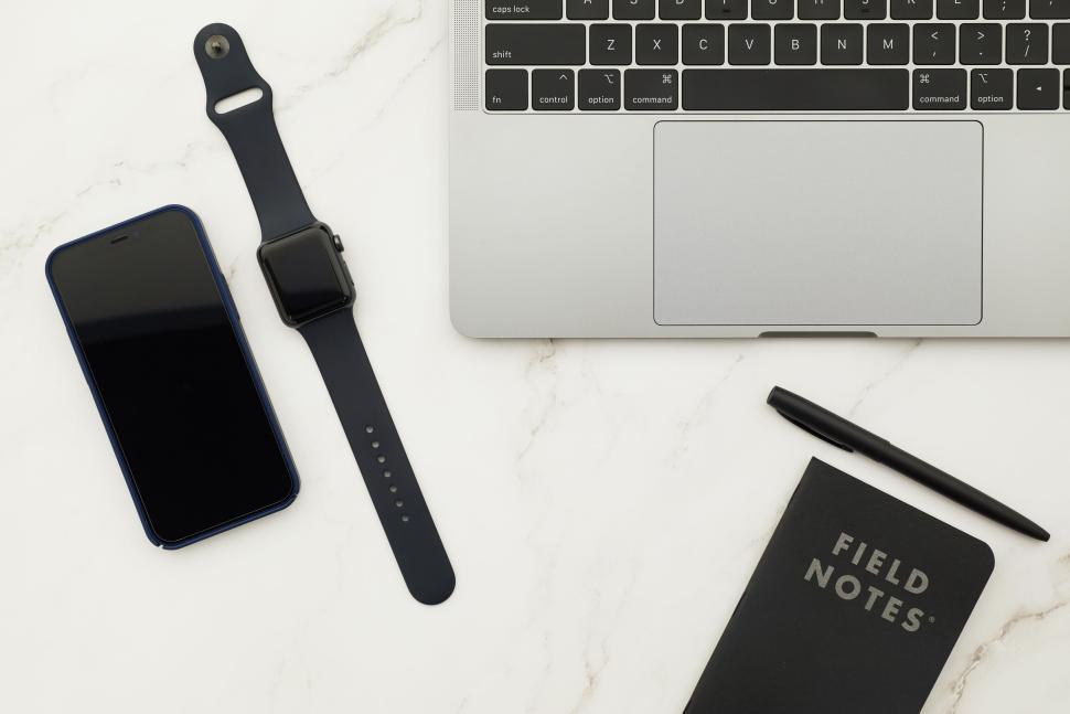 Free Image of Smartwatch, smartphone, notebook, and laptop on marble. 
