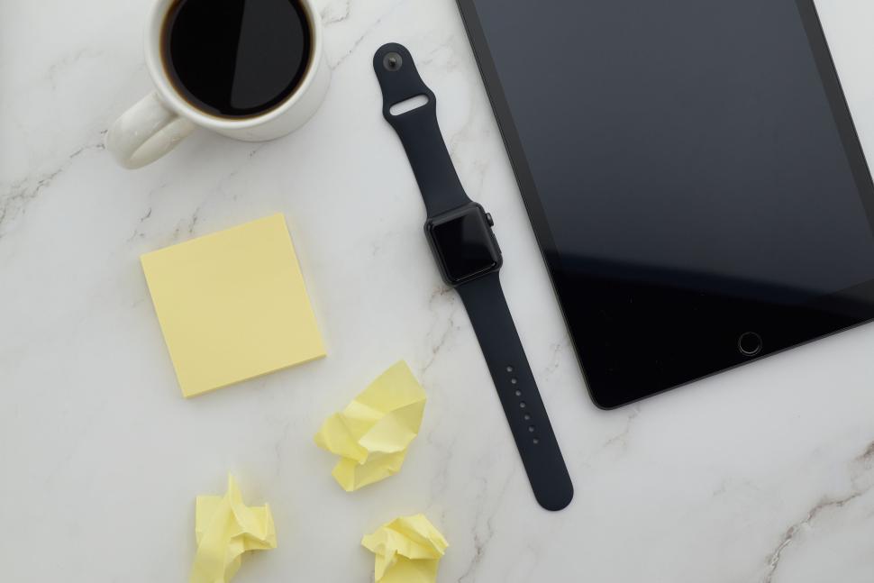 Free Image of Smartwatch, tablet, coffee, and notes on marble surface. 