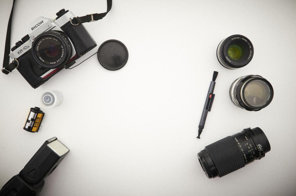 Free Image of Camera and lenses on white surface with accessories 