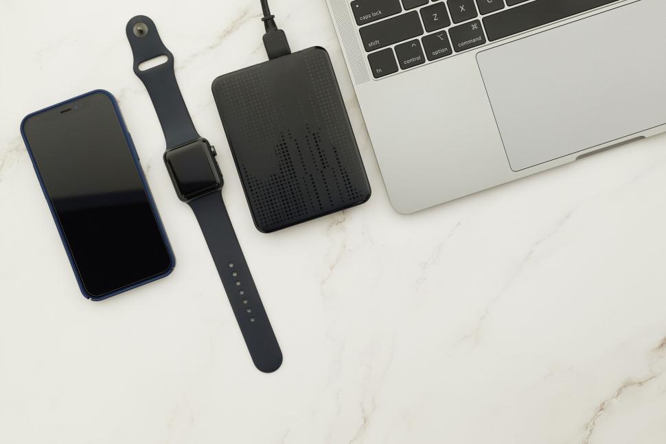 Free Image of Smartwatch smartphone and external hard drive with laptop 