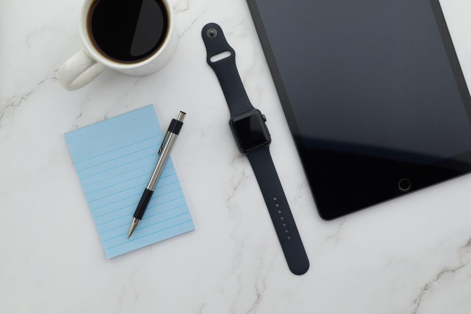 Free Image of Smartwatch, tablet, notepad, pen, coffee on desk 