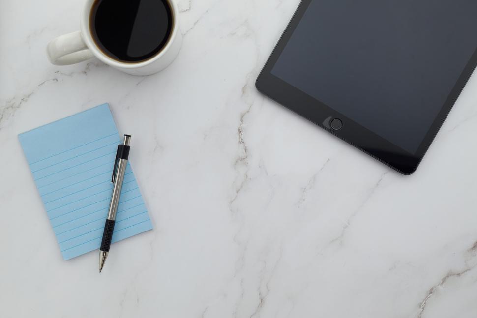 Free Image of Tablet with blue notepad, pen, and coffee on desk 