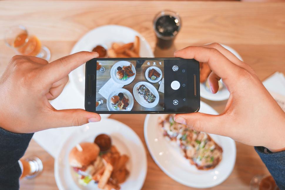 Free Image of Person taking photos of assorted dishes with a smartphone 