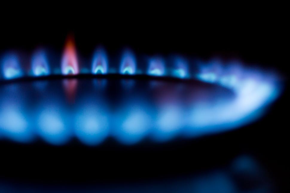 Free Image of Blue flame of a gas burner on a stove in a dark setting. 