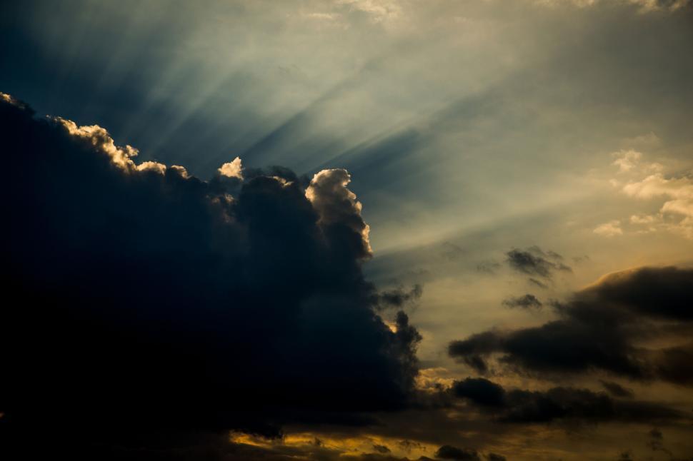 Free Image of Dramatic sunset with clouds and sunbeams breaking through. 