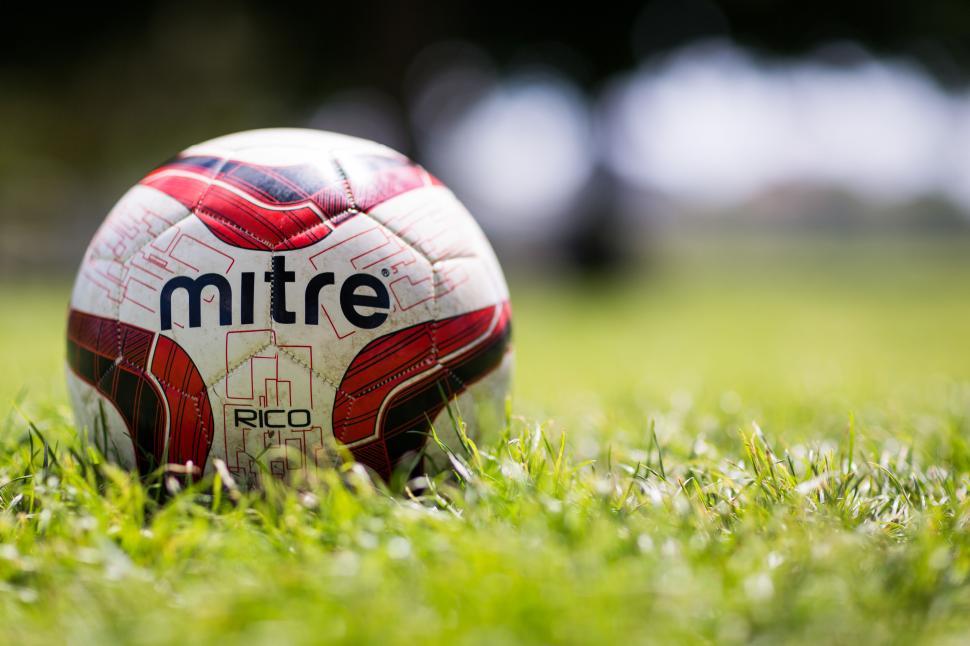 Free Image of Colorful Mitre soccer ball on grassy field outdoors. 