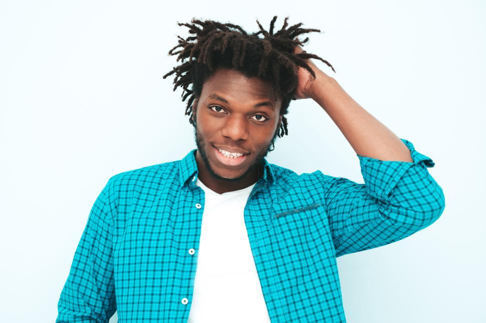 Free Image of Man in blue checkered shirt with hand on his hair. 