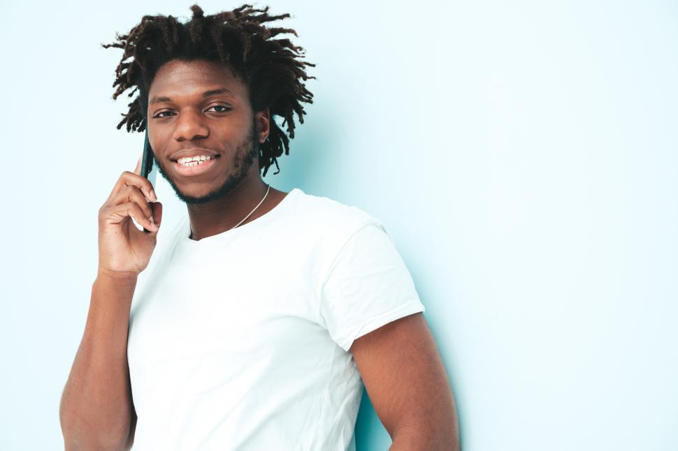 Free Image of Man in white T-shirt talking on smartphone happily. 