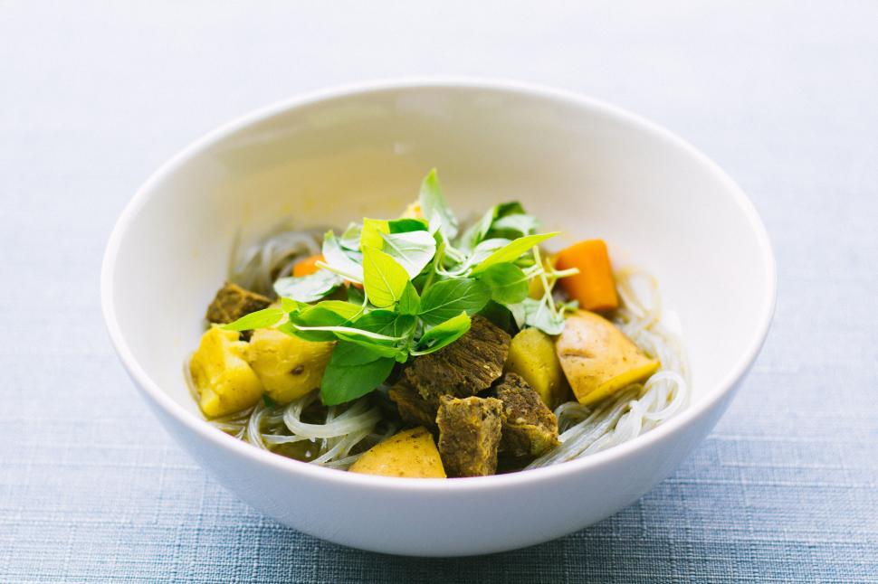 Free Image of Bowl of Vietnamese cuisine with fresh herbs and noodles 