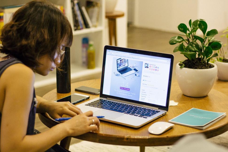 Free Image of Person working diligently on the laptop at home table 