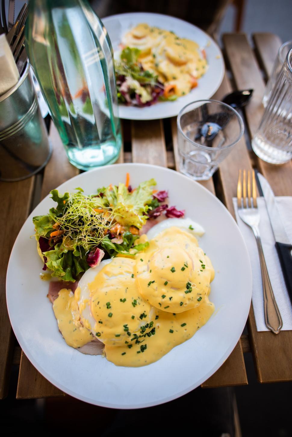 Free Image of Plate with Eggs Benedict and Salad on a Wooden Table 