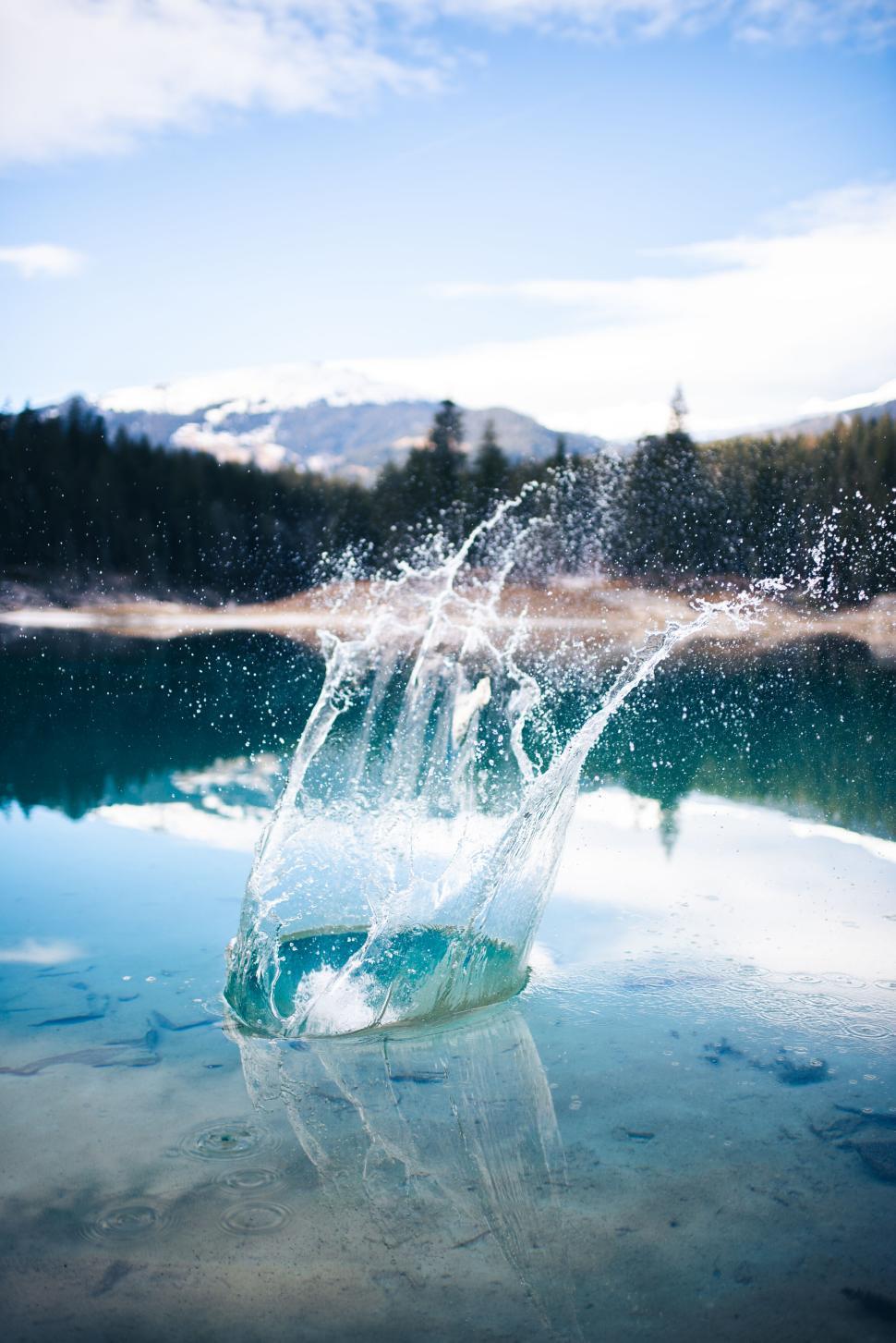 Free Image of Splashing water creating ripples in a clear lake. 