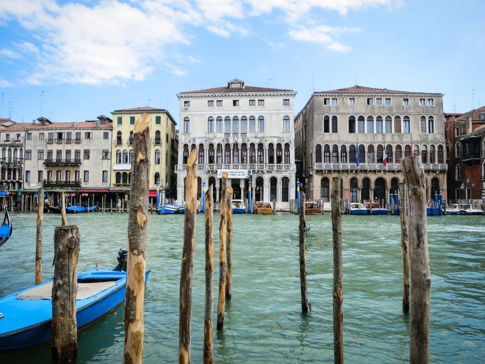 Free Image of Historic buildings with boats on the calming water 