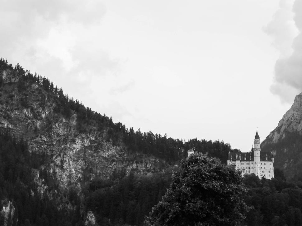 Free Image of Medieval castle nestled among dense forested hills. 