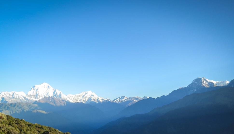 Free Image of Snow-capped mountains with clear blue sky view. 