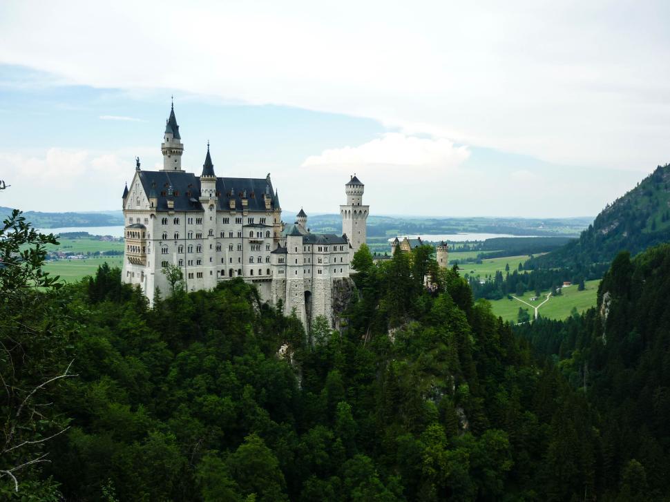 Free Image of Historic castle on a lush green hill with scenic view. 