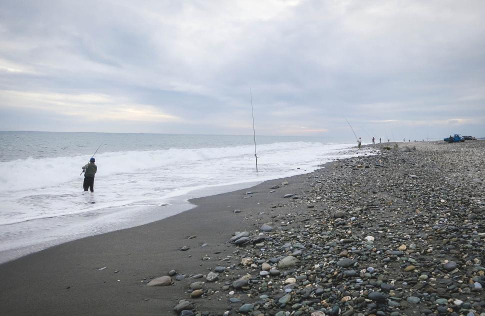 Free Image of Fishermen Casting Lines on a Rocky Beach at Dusk 
