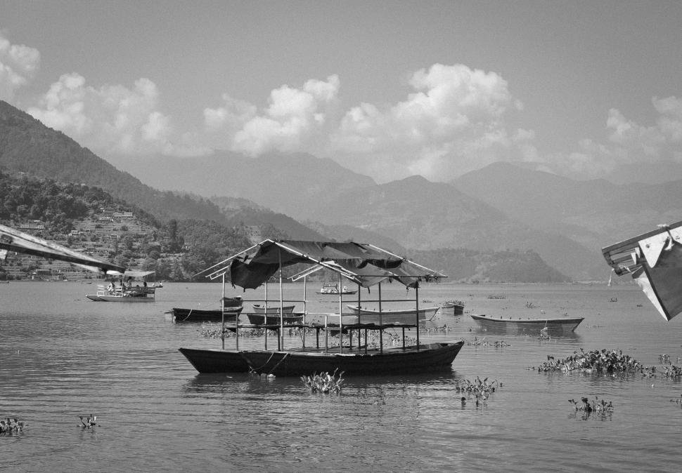 Free Image of Tranquil boat ride on serene lake with distant mountain views 