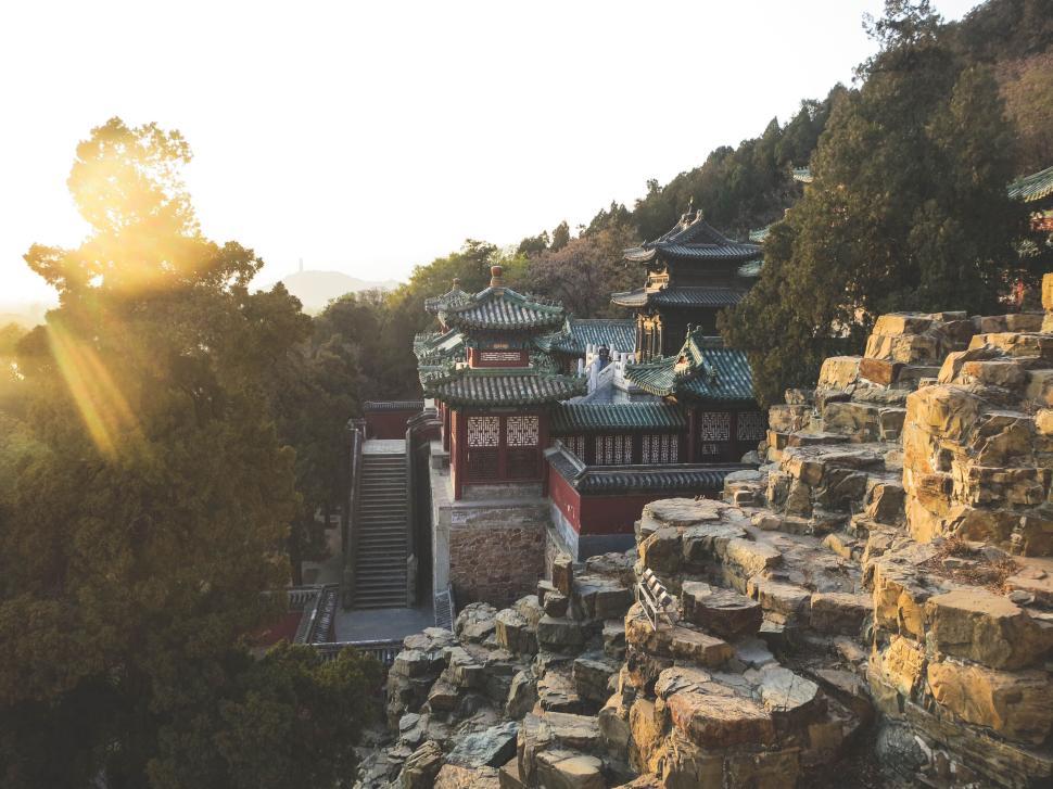Free Image of Ancient Chinese temple amidst rocks with sun setting 