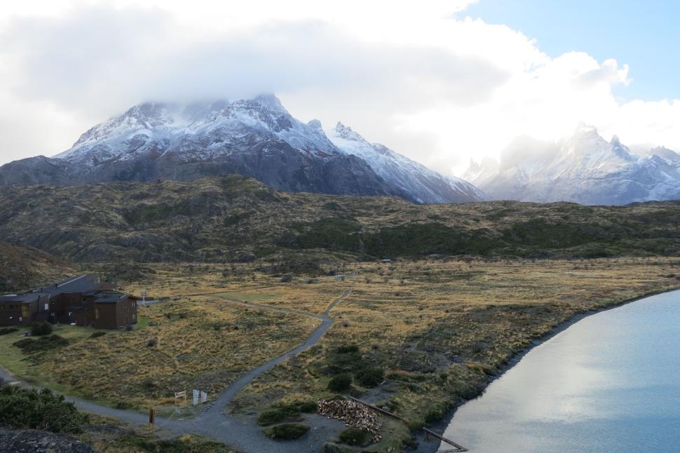 Free Image of Snow-capped mountains and barren land by the water. 