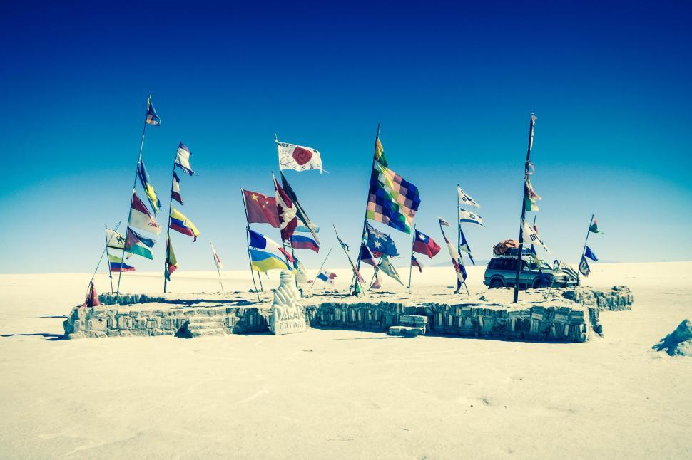 Free Image of Flags from different countries on sand flats desert 