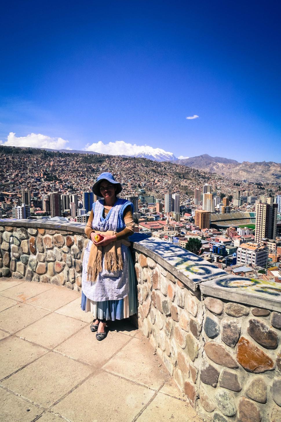 Free Image of Woman in traditional dress with mountain city view. 