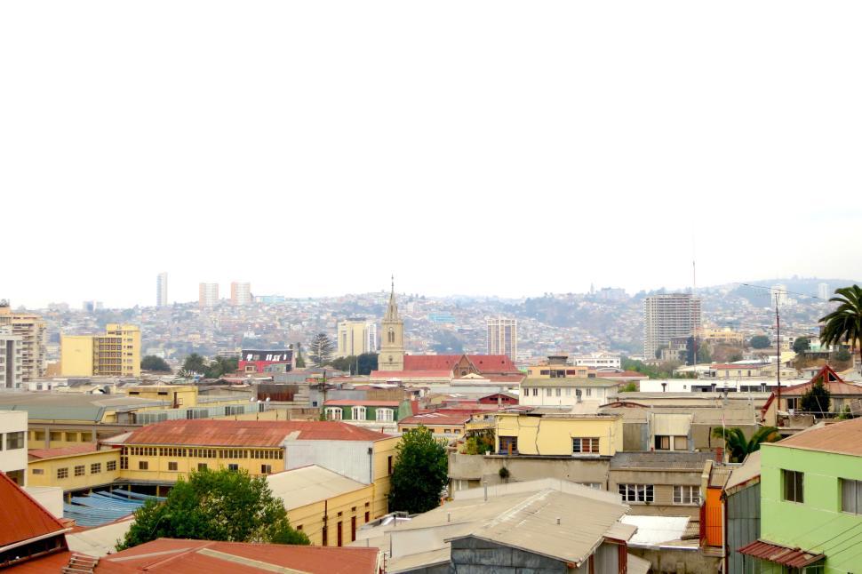 Free Image of Cityscape with diverse architecture and distant hills. 