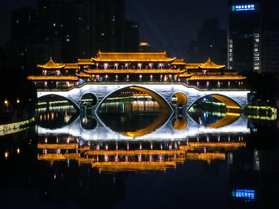 Free Image of Illuminated bridge reflecting on calm river at night 