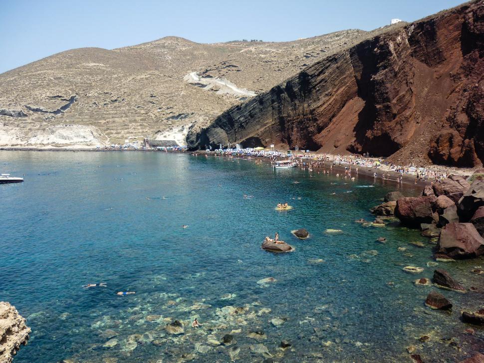 Free Image of Beautiful beach with deep blue water and red rocks 