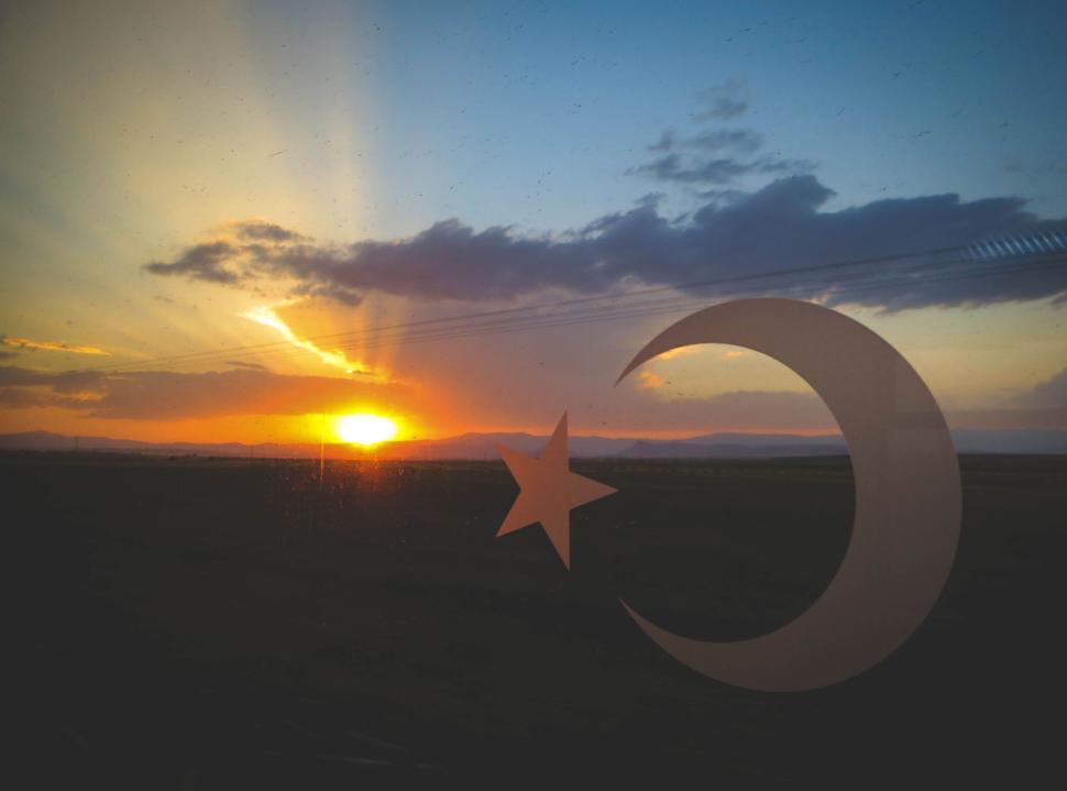 Free Image of Sunset view through the crescent and star symbol 