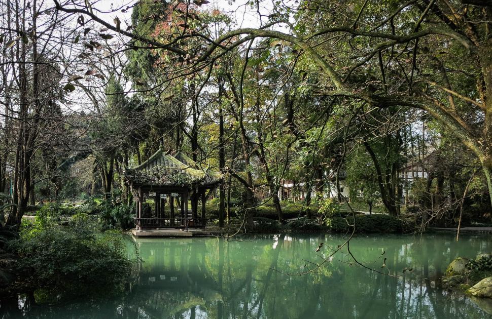 Free Image of Traditional pavilion by a tranquil pond in lush greenery 
