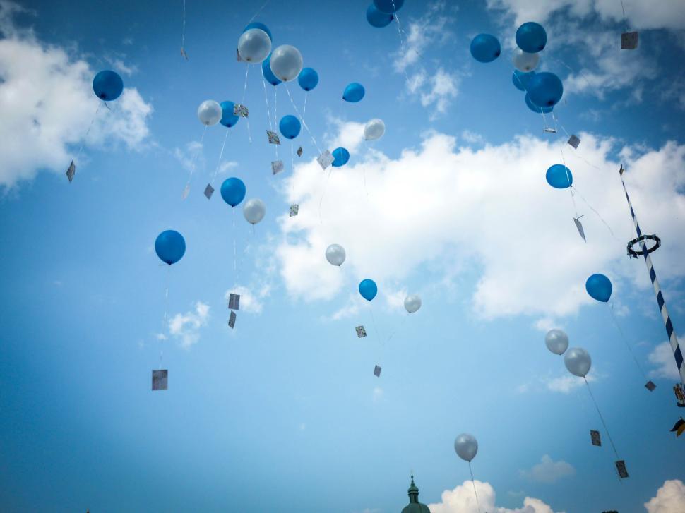 Free Image of Blue and white balloons released into the sky 
