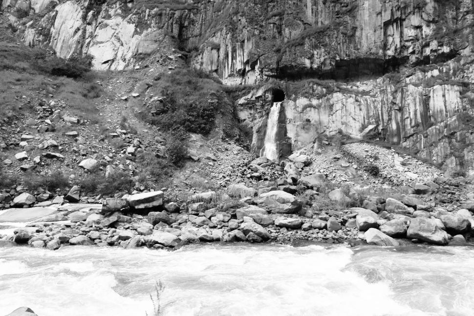 Free Image of Raging river flowing beneath rocky mountainous terrain 