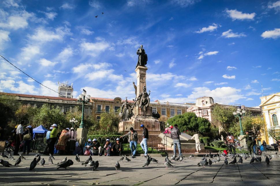 Free Image of Statue in a busy city square in La Paz, Bolivia with pigeons around 