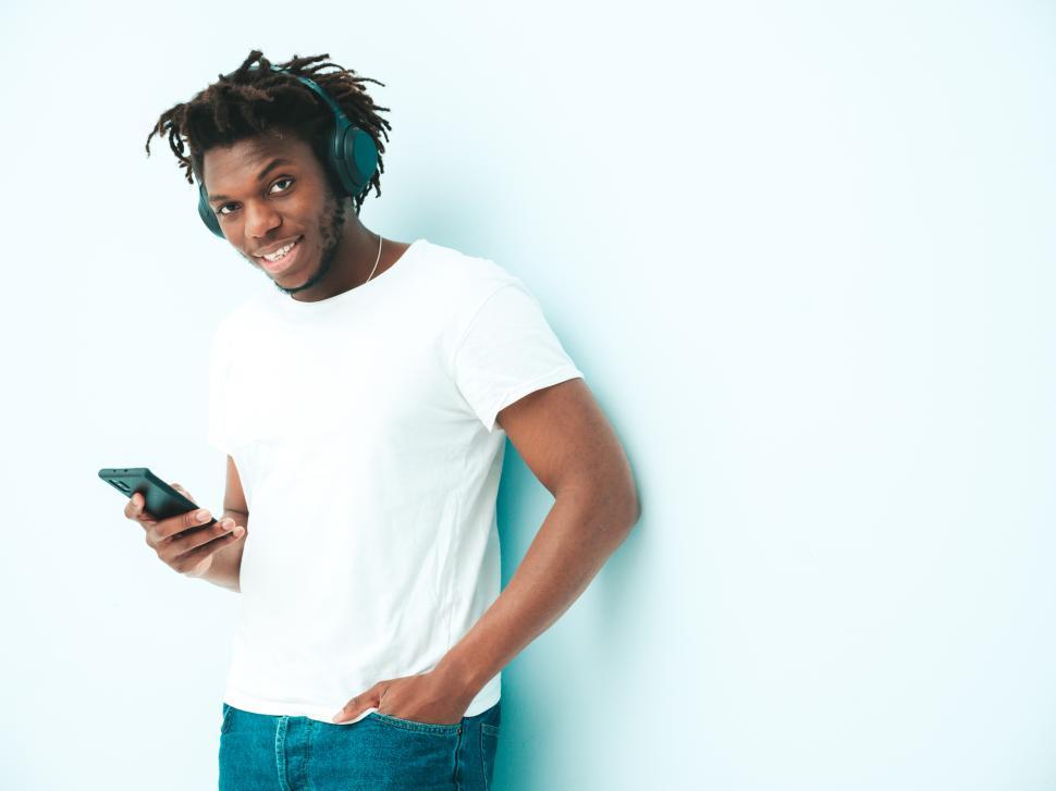Free Image of Man listening to music with headphones on smartphone. 