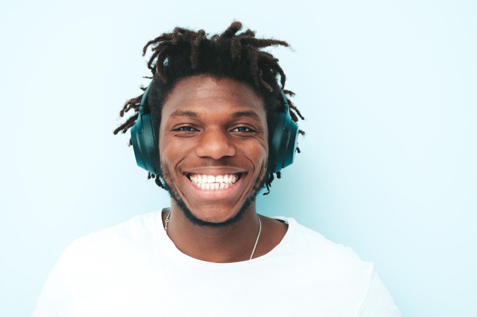 Free Image of Smiling man with large headphones in white shirt. 