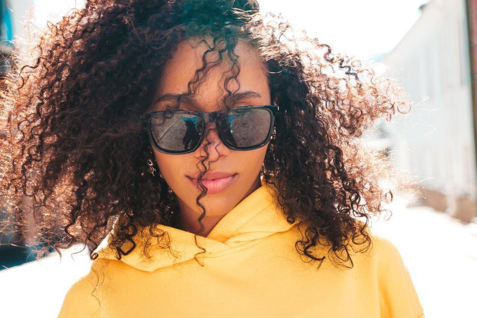 Free Image of Close-up of curly hair in bright yellow hoodie 