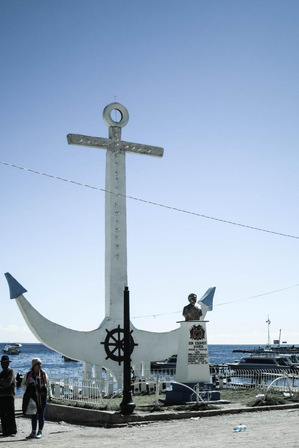 Free Image of Large anchor statue near waterfront under clear blue skies. 