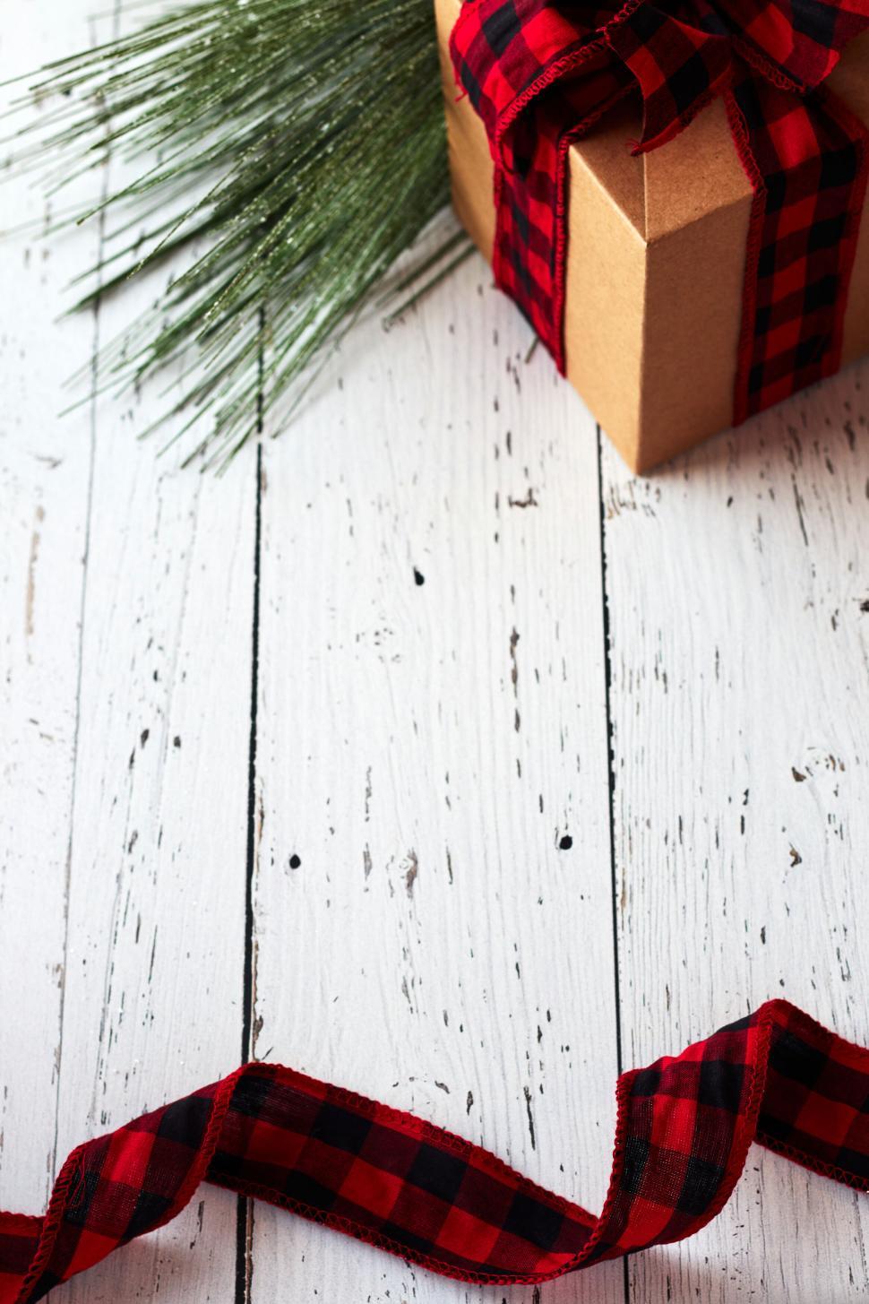 Free Image of A beautifully wrapped gift box with a checkered ribbon. 