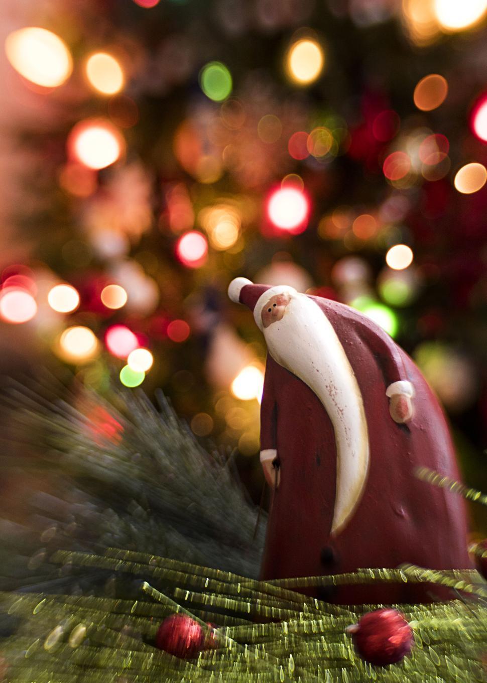 Free Image of Christmas figurine with colorful bokeh lights blurred 